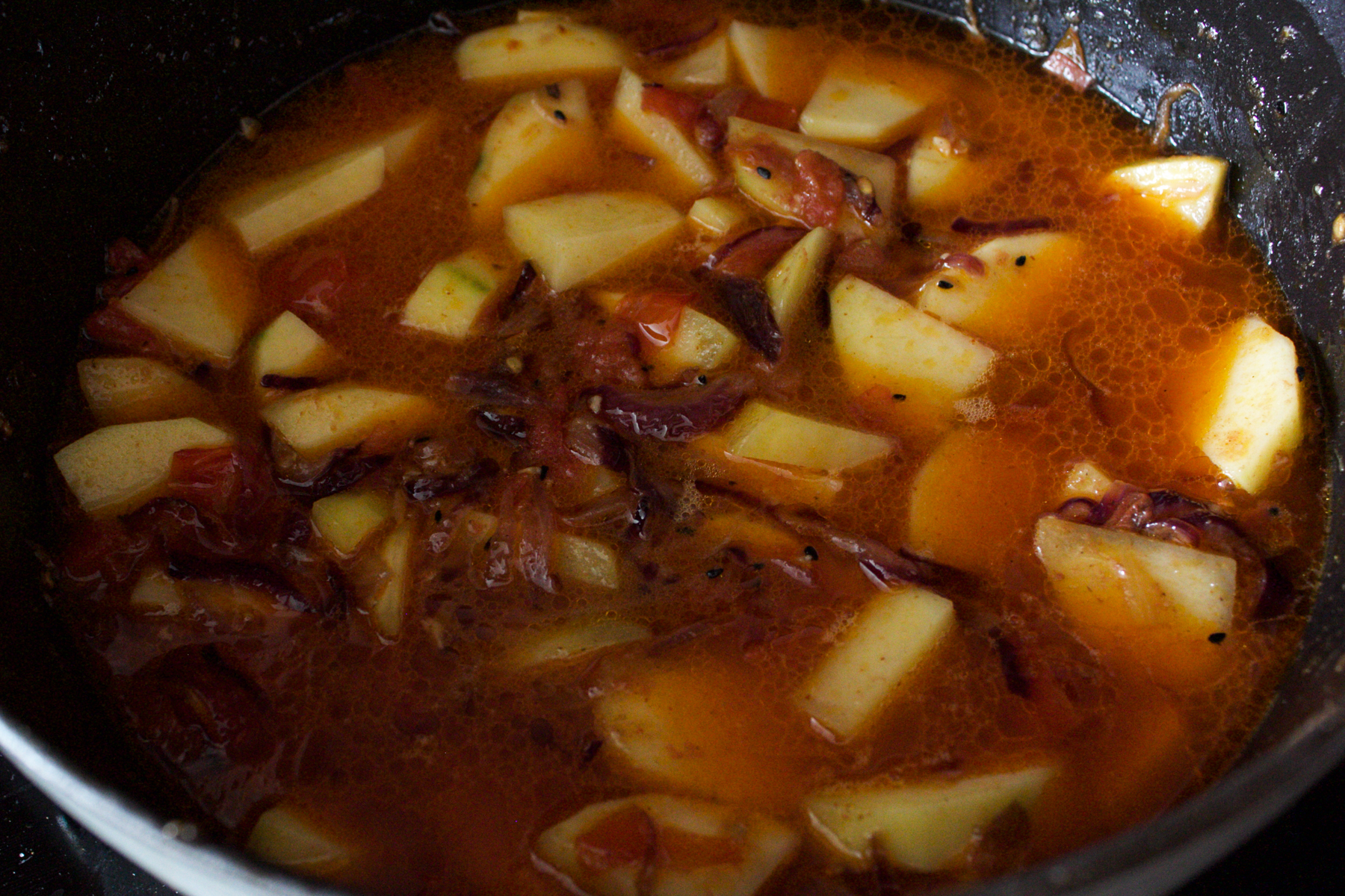 Adding water to potato curry 