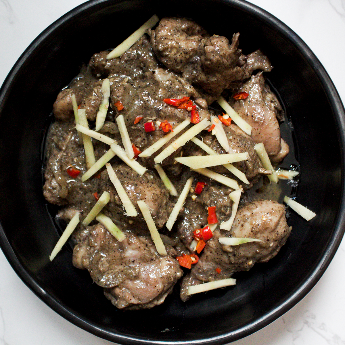 kali mirch chicken karahi in a bowl with ginger and chili garnish 