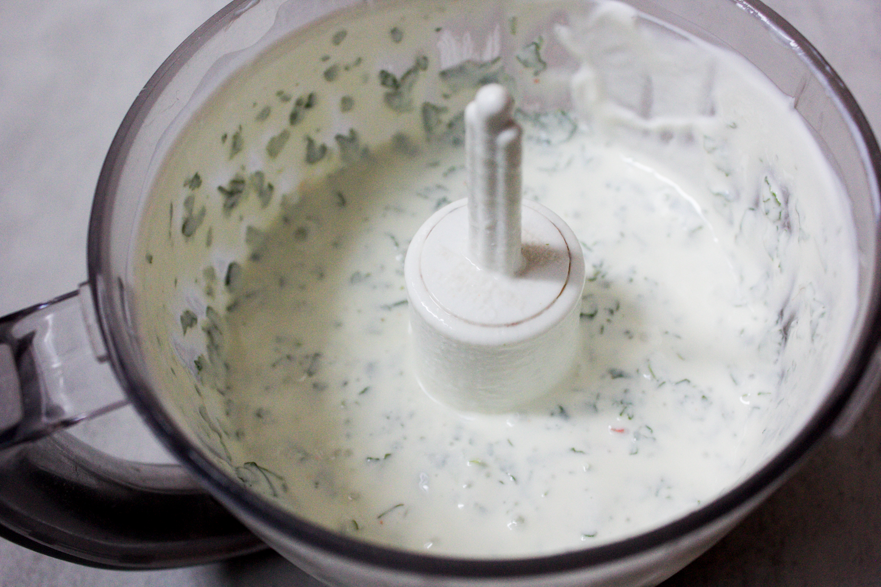 Yogurt, cilantro, mint and chili mixture in food processor 