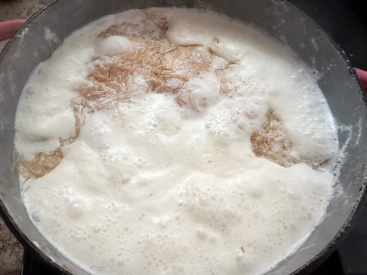 Lowering the pot of seviyan to a simmer