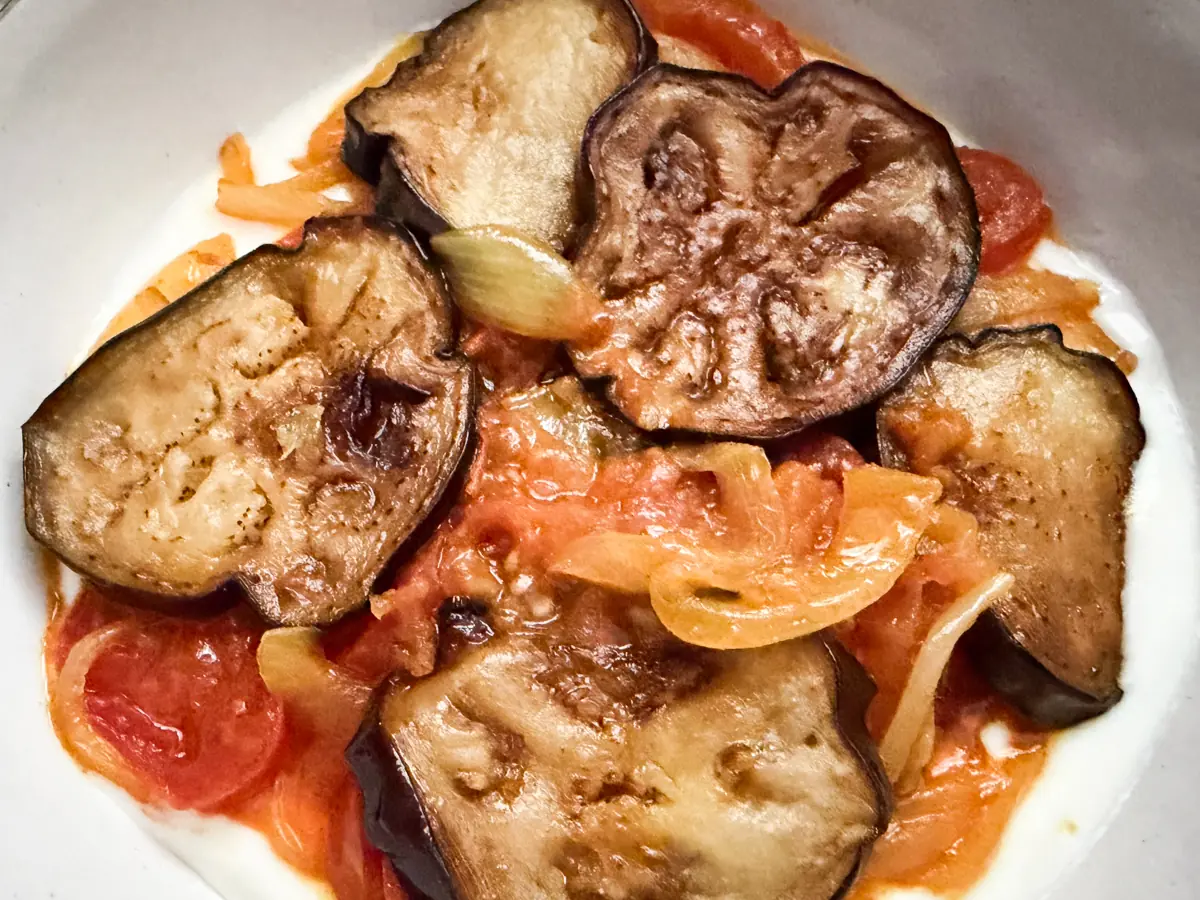 eggplant, tomato and onion curry layered on top of whisked yogurt